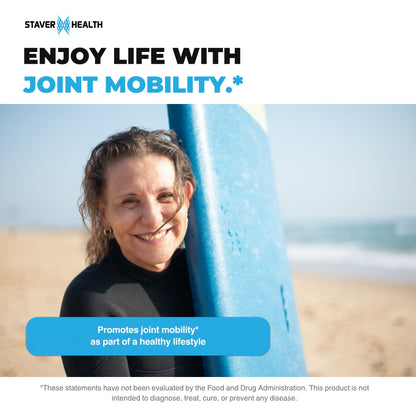 Smiling woman in a wetsuit holding a surfboard on a sunny beach